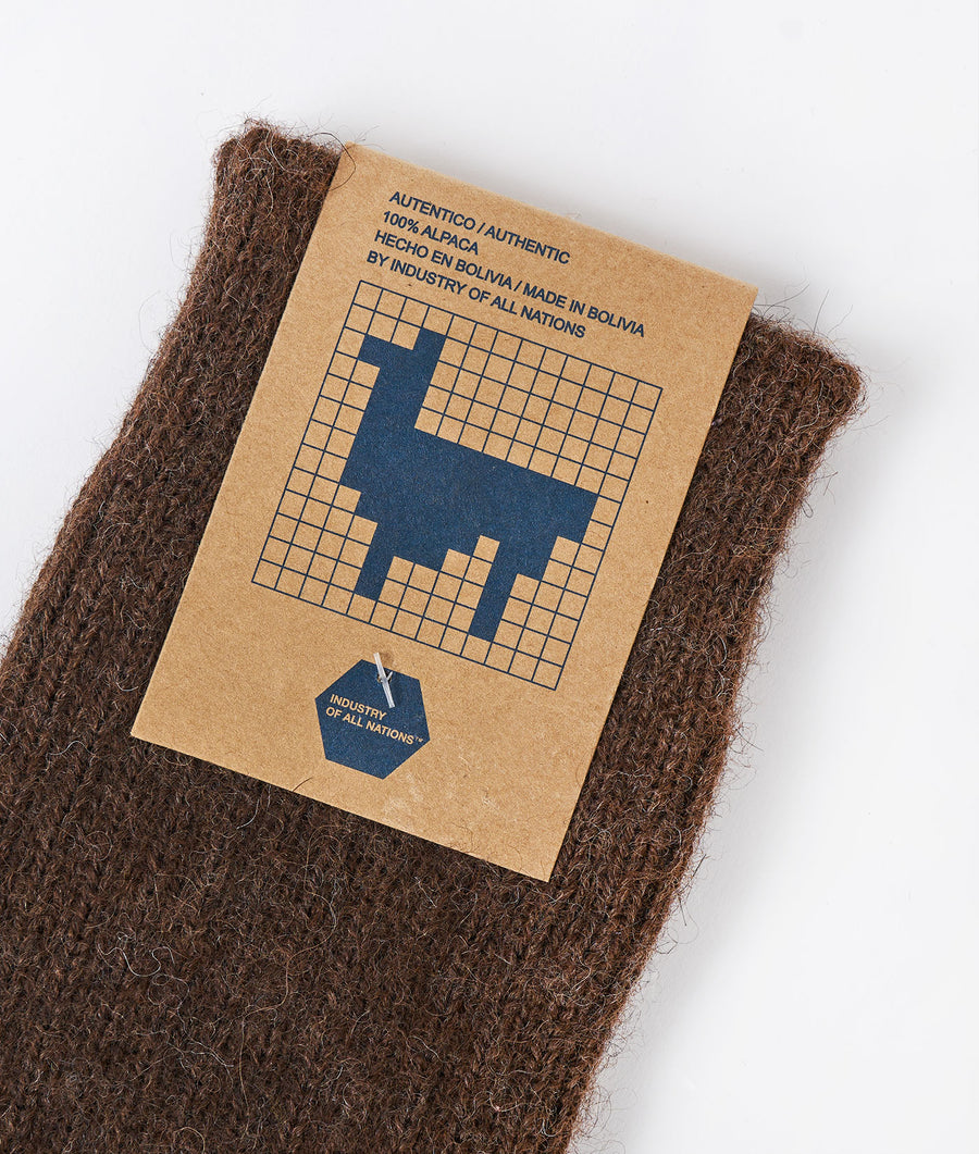 A brown, wool alpaca scarf or wrap lying on a white background with a label reading 'Autentico/Authentic' - Industry of All Nations