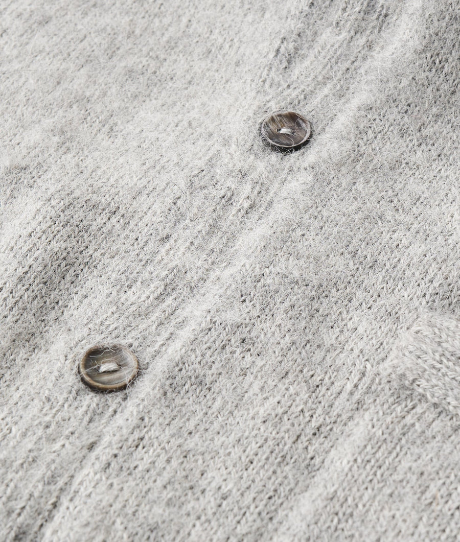 Close-up detail shot of a gray wool garment with buttons - Industry of All Nations