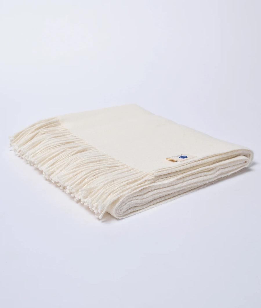 Creamy white woollen blanket with fringed edges, displayed in a flat lay arrangement - Industry of All Nations