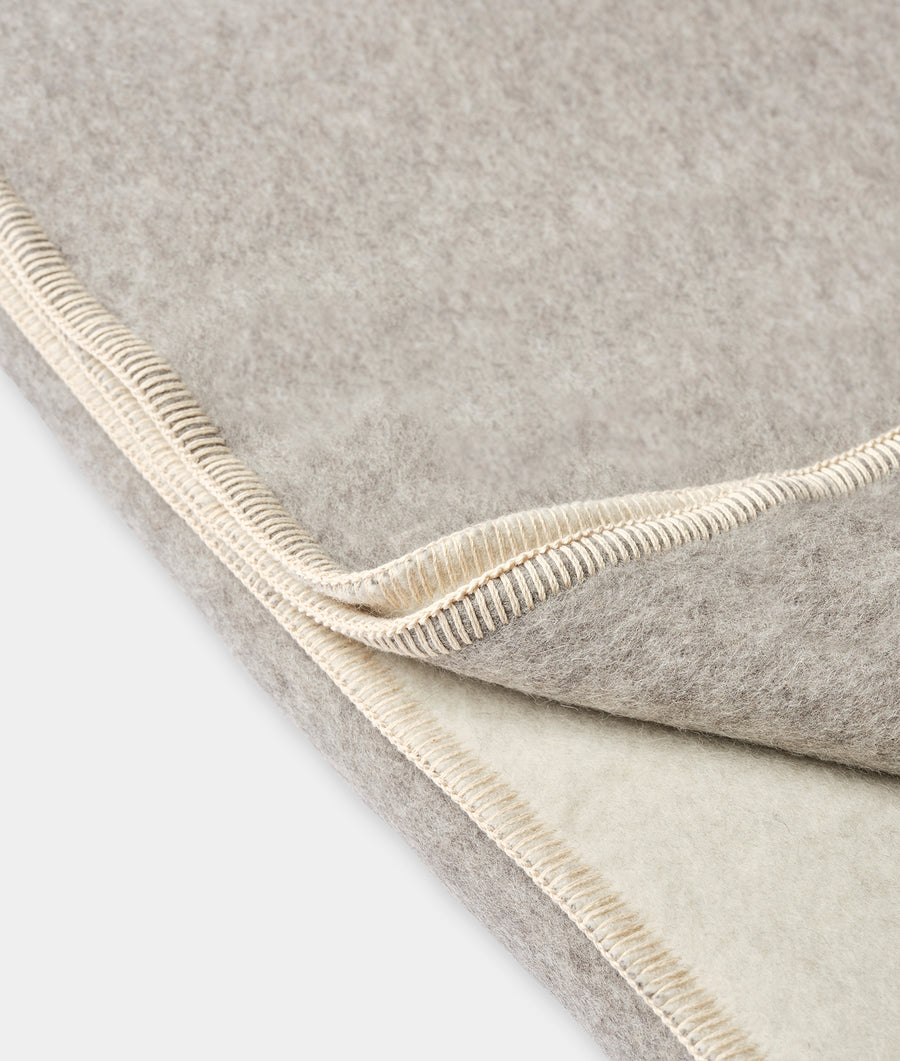 Detail shot of a grey wool blanket with a light beige binding - Industry of All Nations