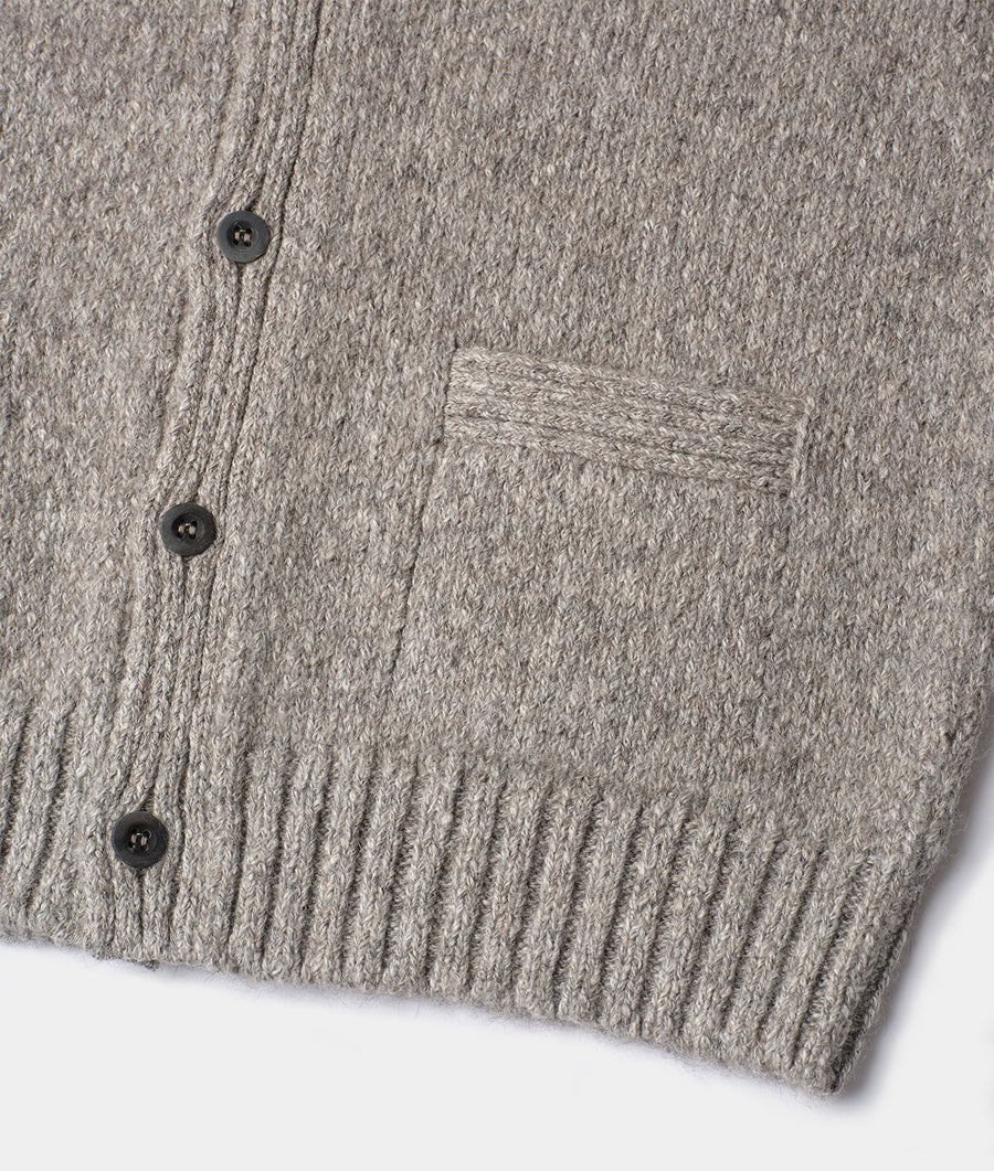 Close-up shot of a heather gray knit cardigan with a ribbed pattern and buttons, displayed flat on a surface - Industry of All Nations
