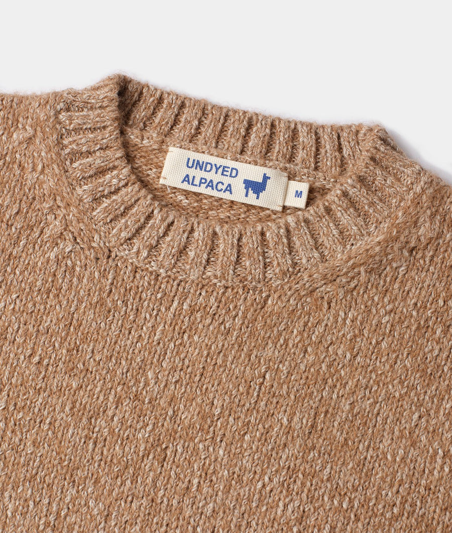 Tan alpaca sweater with ribbed collar and "Undyed Alpaca" label, displayed in a flat lay - Industry of All Nations