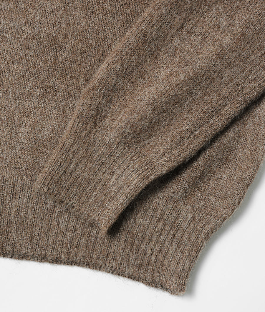 Close-up detail shot of a beige/brown wool knit sweater fabric - Industry of All Nations
