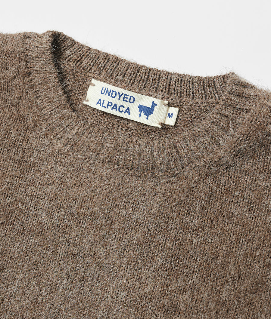 Close-up of a brown alpaca wool sweater or jumper with an "UNDYED ALPACA" label - Industry of All Nations