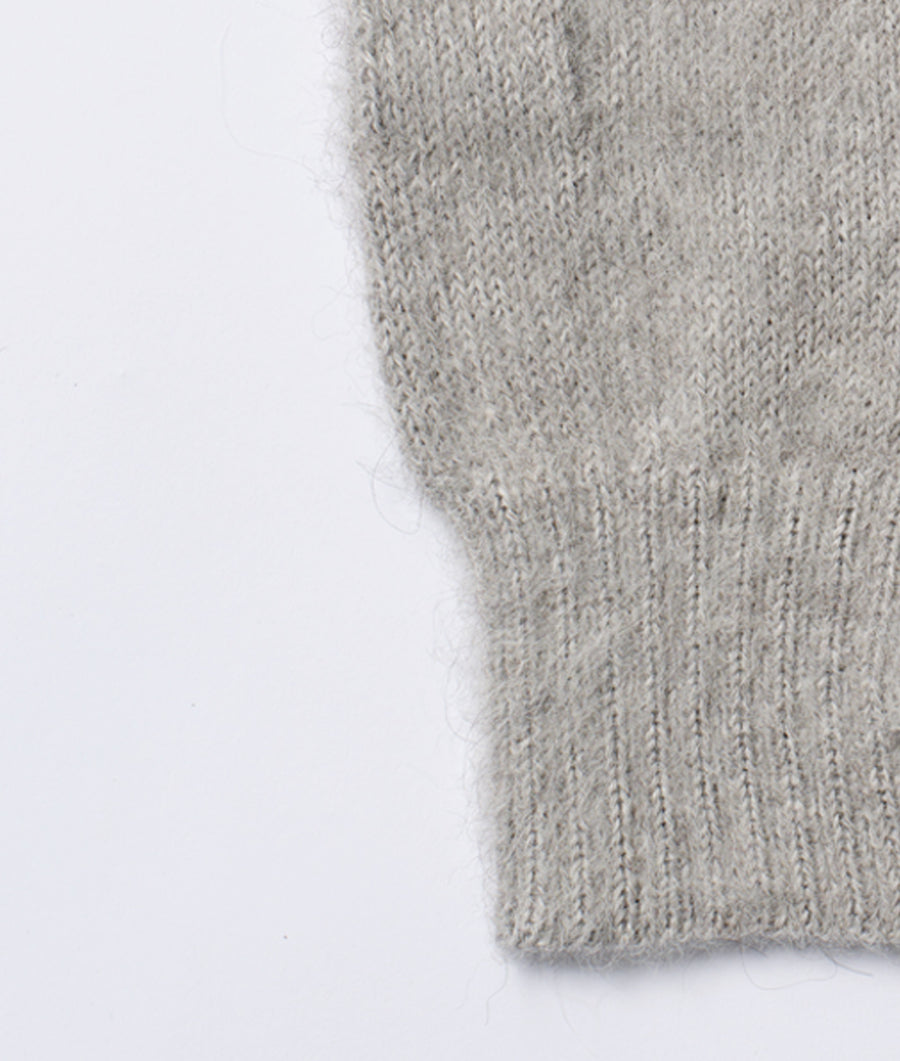 A close-up detail shot of a gray, knitted garment - Industry of All Nations