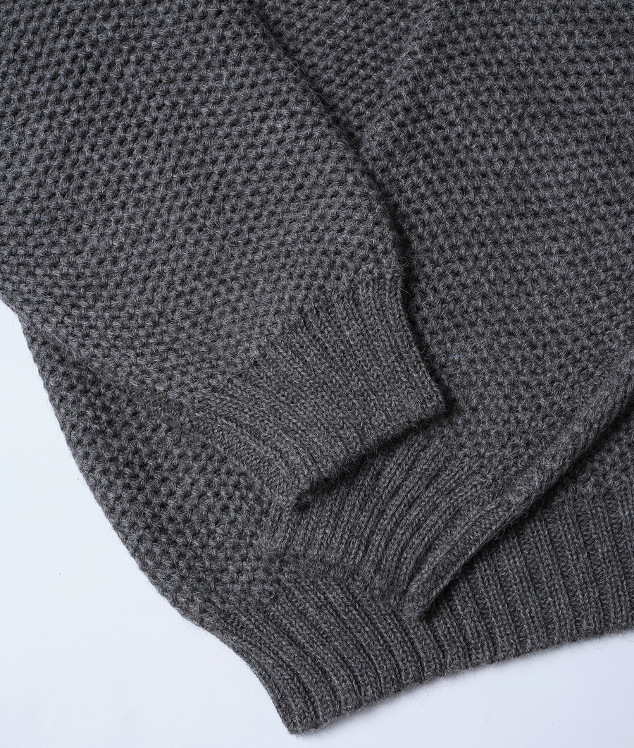 Close-up detail shot of a charcoal gray knit sweater from Industry of All Nations.