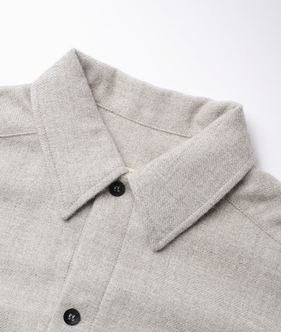 Close-up detail shot of a gray knit sweater or cardigan with black buttons - Industry of All Nations