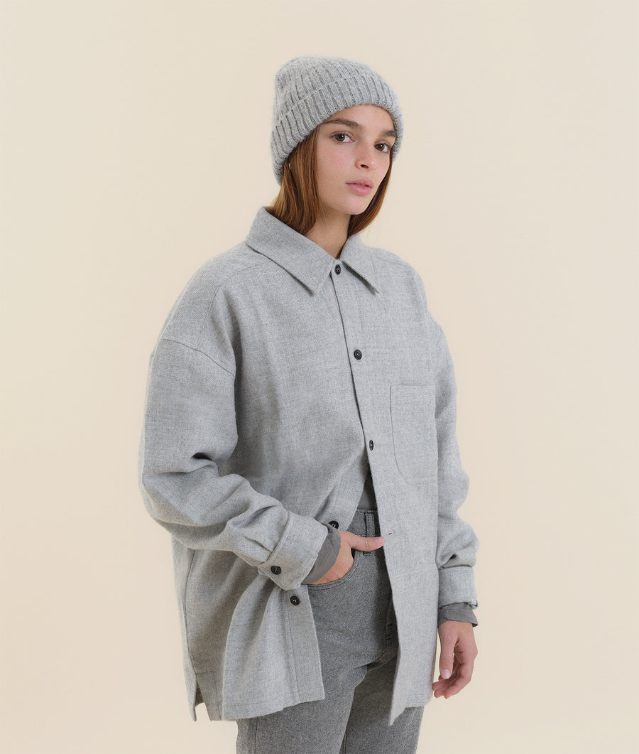 A model wearing a gray wool coat over a matching knit hat and pants - Industry of All Nations