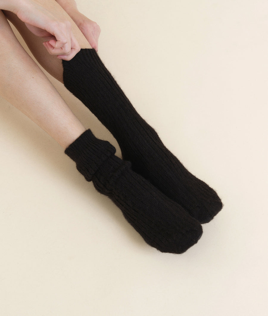 Flat lay of a pair of black, ribbed cotton socks - Industry of All Nations