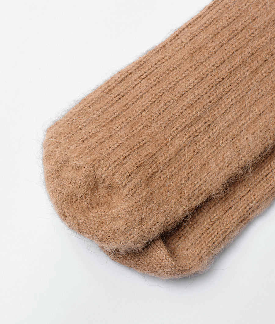 Close-up of a tan, wool sock made by Industry of All Nations.
