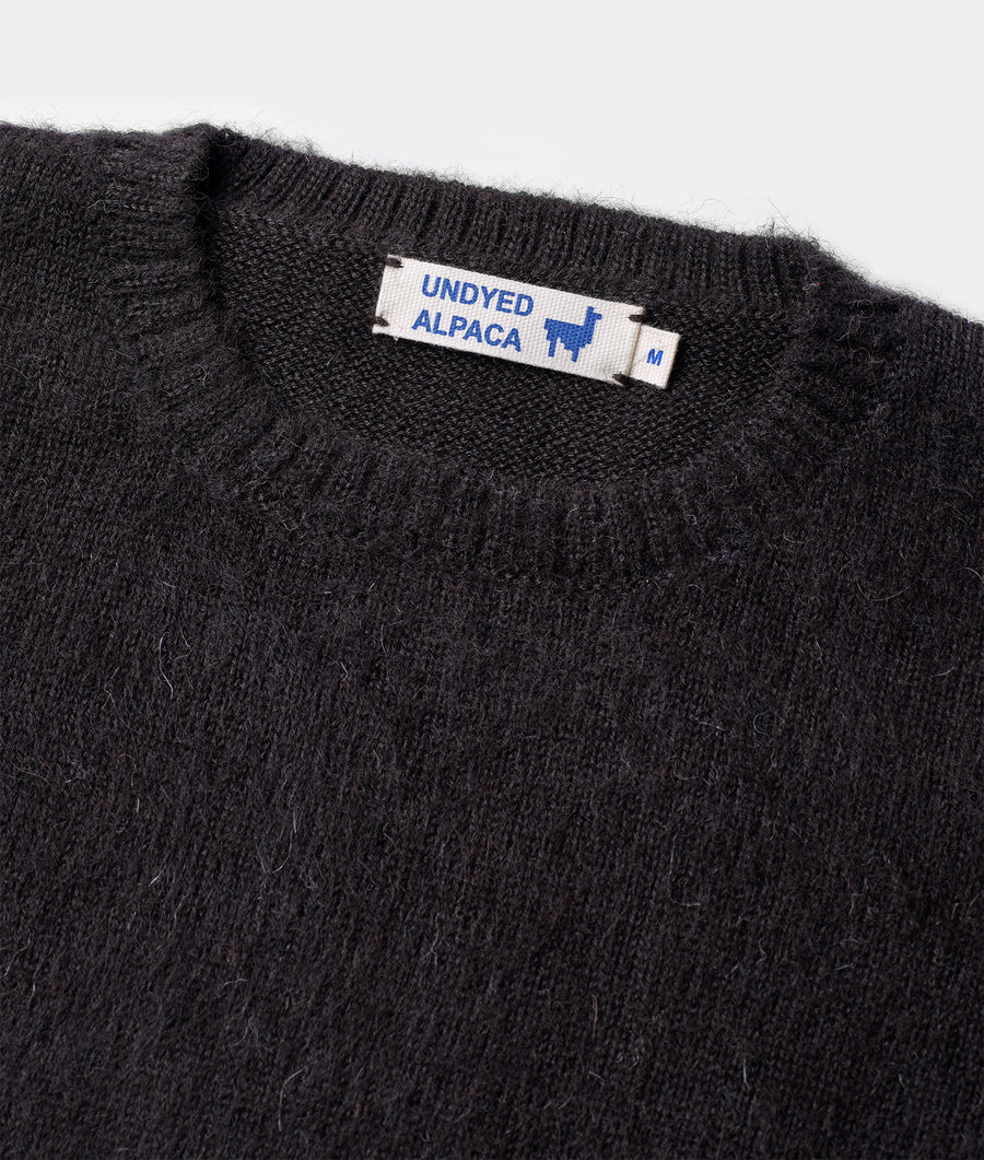 Undyed alpaca sweater in dark gray, displayed in a detail shot - Industry of All Nations