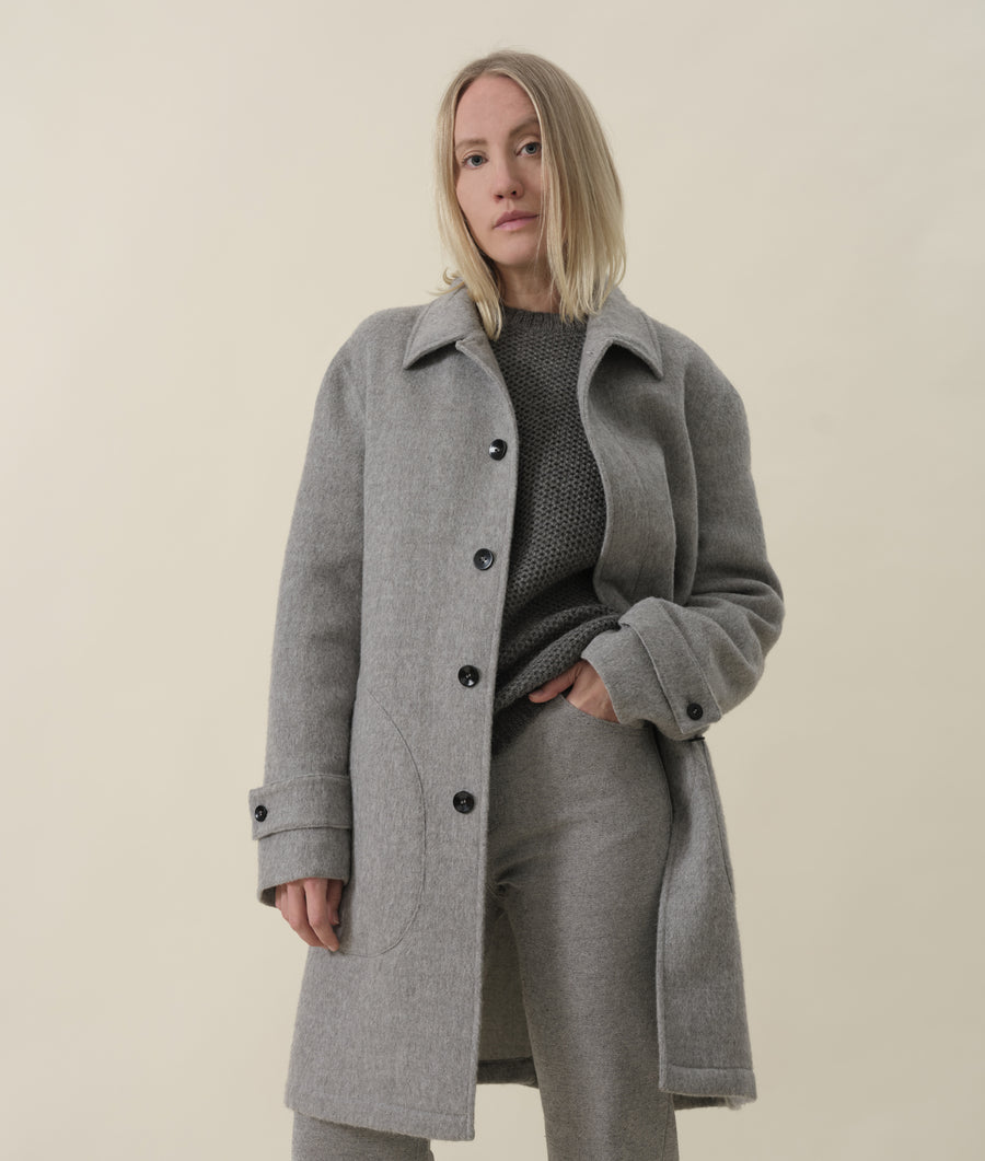 A model wearing a grey wool-blend coat from Industry of All Nations.
