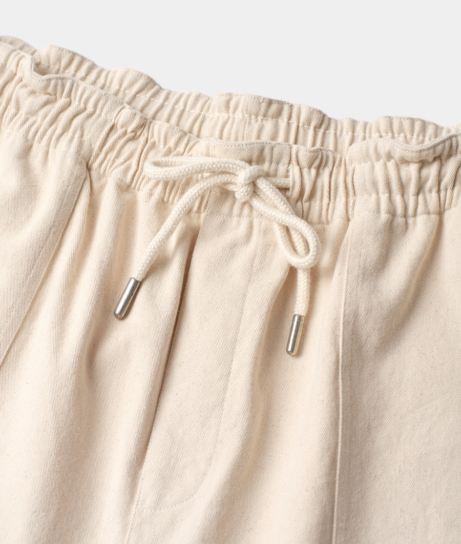 Flat lay detail shot of beige cotton drawstring pants with metal aglets - Industry of All Nations