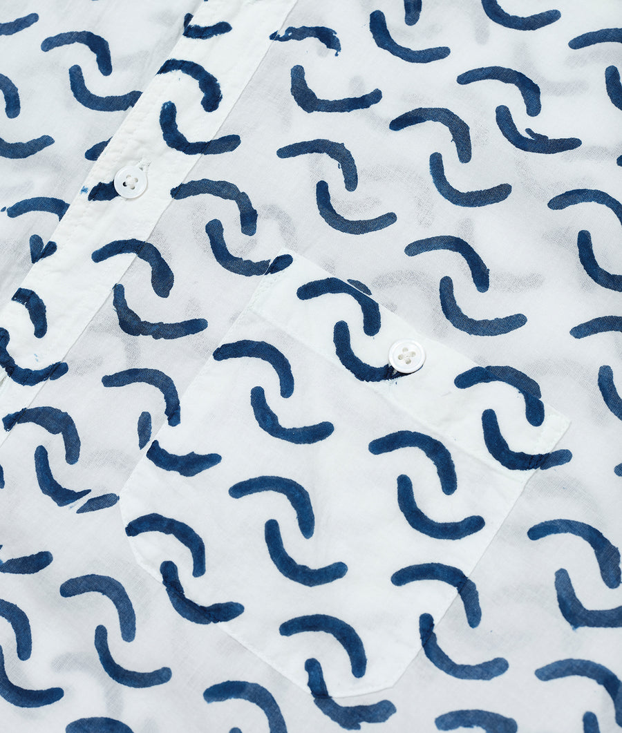 Detail shot of a white button-up shirt with a repeating navy blue wave pattern - Industry of All Nations