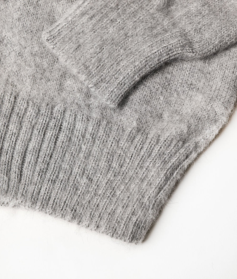 Close-up of a gray knitted sweater, displayed flat against a white background - Industry of All Nations