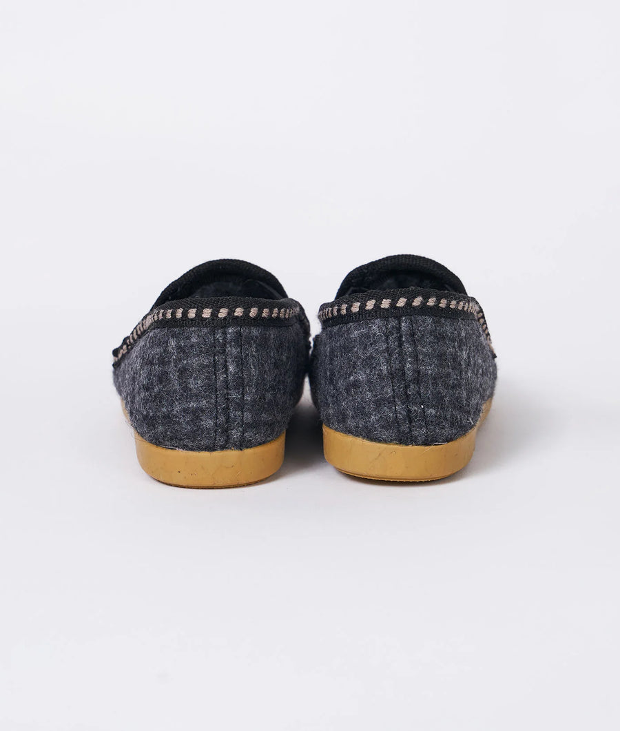 A close-up photograph of a pair of gray felt slippers with a beige sole, displayed on a white background - Industry of All Nations