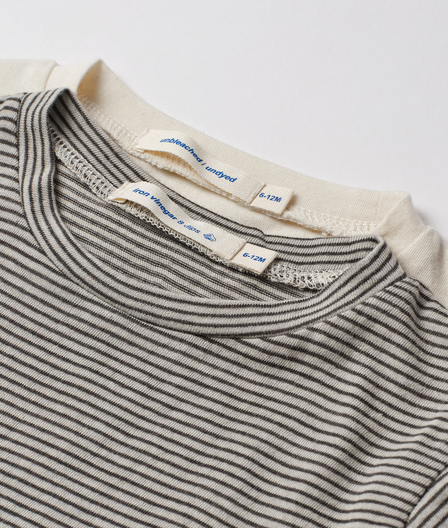 A detail shot of a striped organic cotton garment, likely a shirt or top, in muted gray and white tones - Industry of All Nations