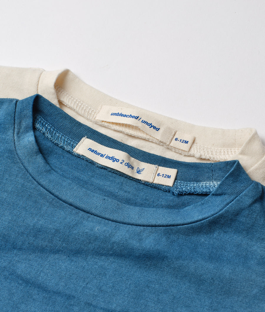 Close-up of a blue organic cotton T-shirt with natural indigo dye and a cream-colored label - Industry of All Nations
