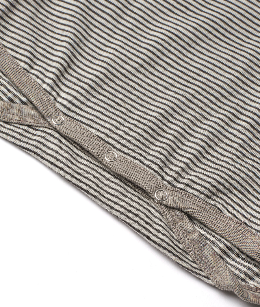 Closeup of a grey and beige striped organic cotton knit sweater displayed on a flat surface - Industry of All Nations
