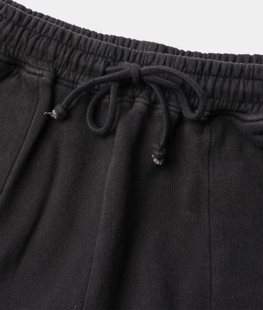 Closeup detail shot of the drawstring waist of a black organic cotton fleece pant - Industry of All Nations.