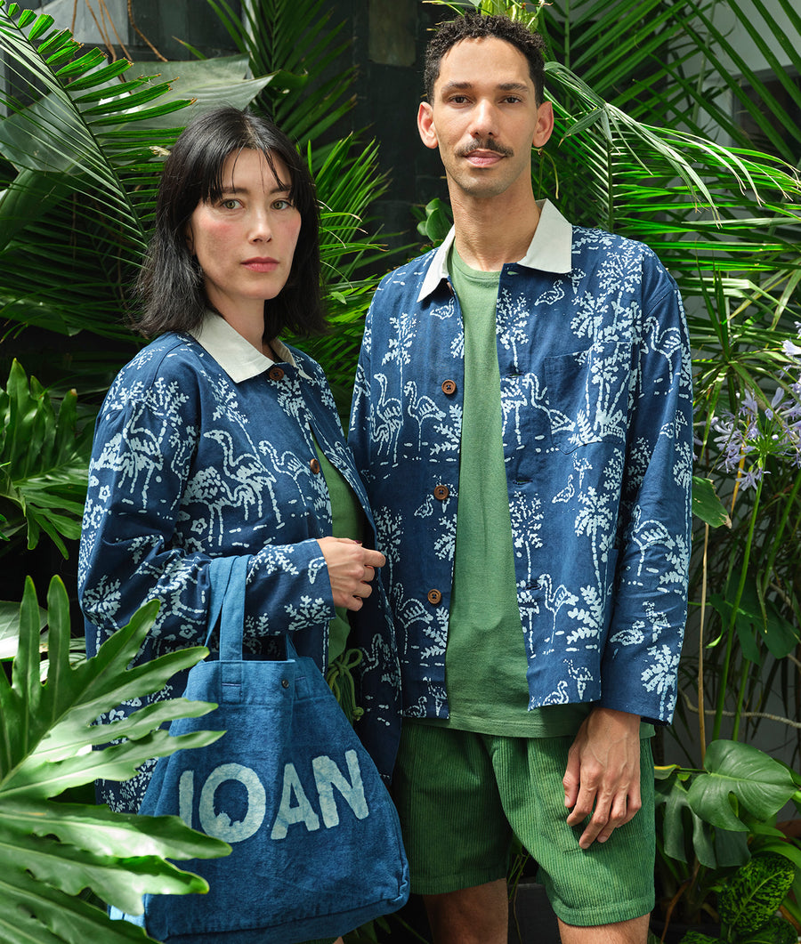 Two people wearing colorful, sustainably-made clothing featuring a floral print - Industry of All Nations