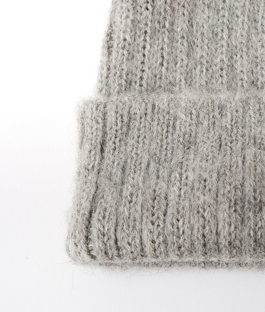 Detail shot of a gray knitted sweater or garment from Industry of All Nations.
