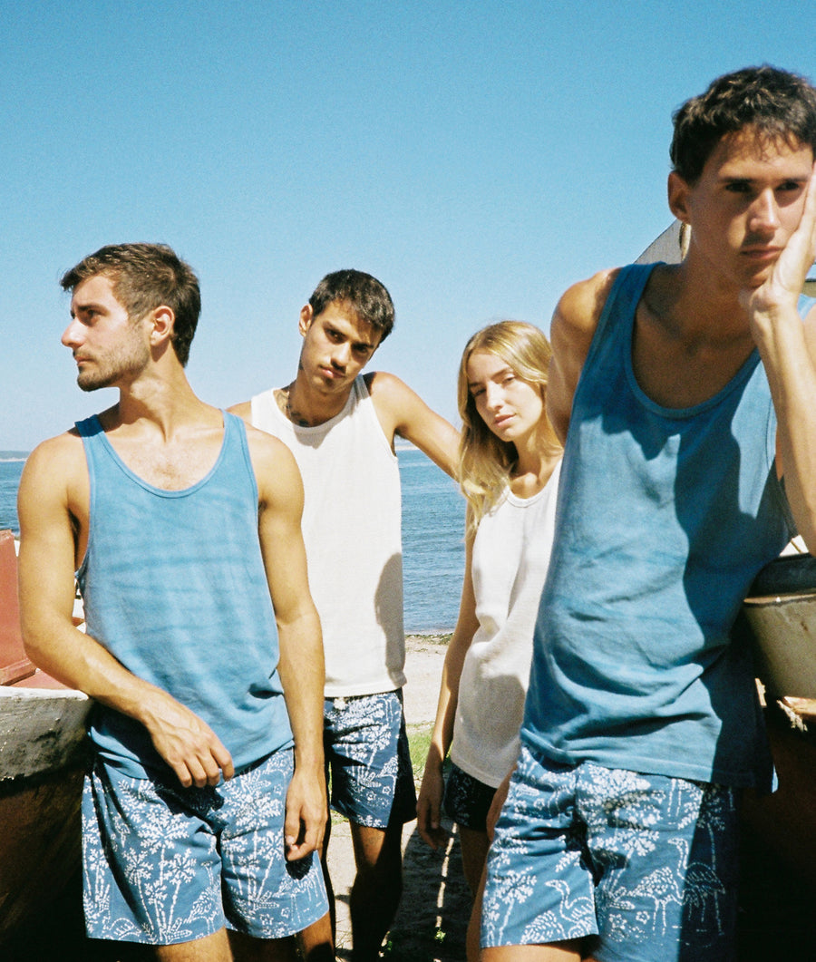Four young adults standing outdoors in casual summer attire - Industry of All Nations