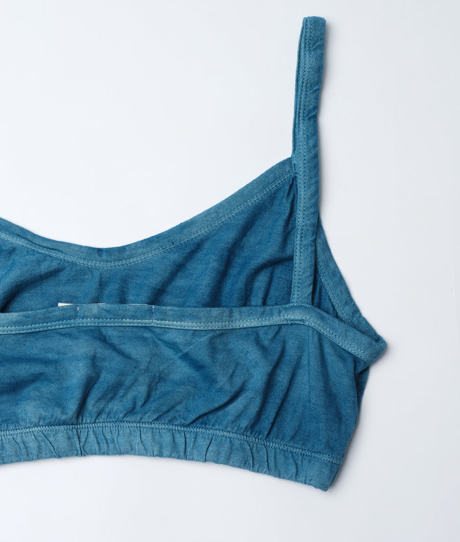 Closeup shot of teal sports bra with ribbed details, displayed flat against a white background - Industry of All Nations