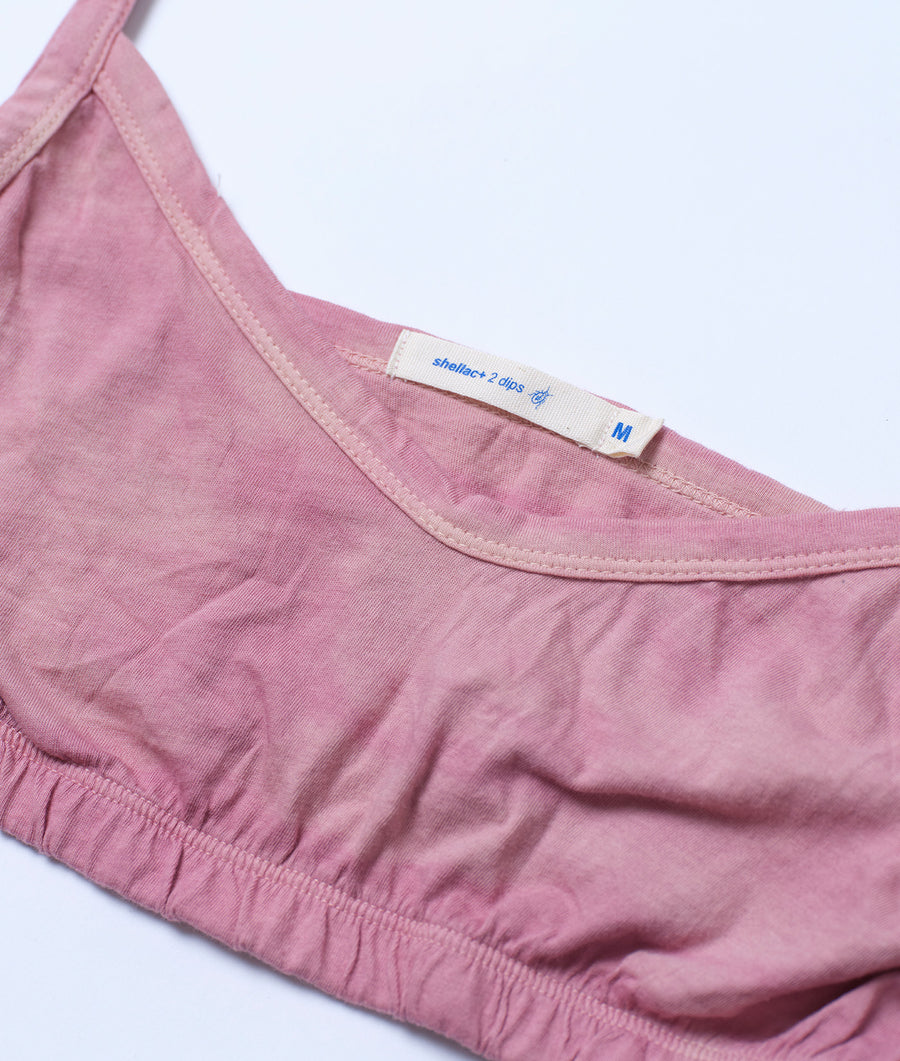 Close-up detail shot of a pink cotton women's tank top with a label that says 'shellac+ 2 clips' - Industry of All Nations