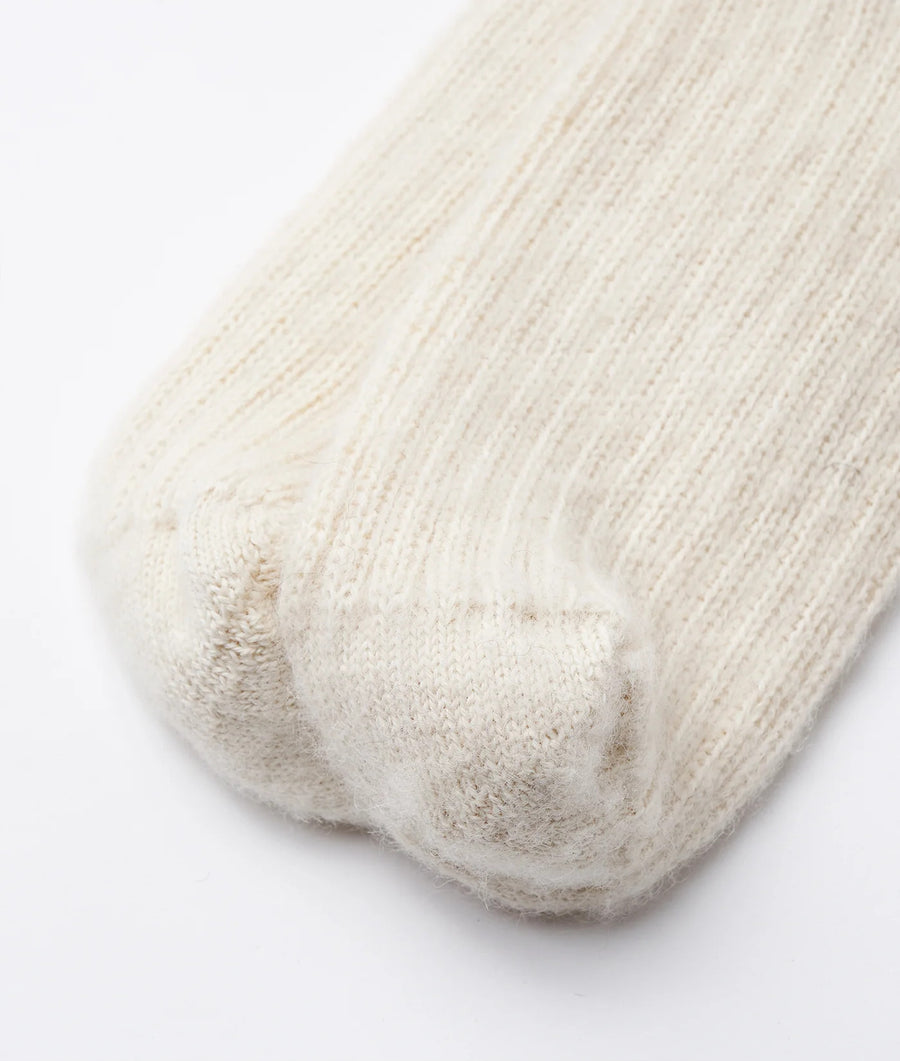 Detail shot of a light cream-colored knitted alpaca sock with a soft, fluffy texture - Industry of All Nations