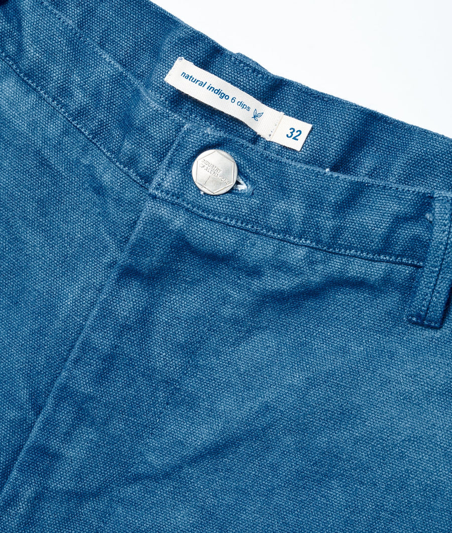 A close-up detail shot of a pair of blue denim jeans with a size tag that says "Natural indigo 6 dips 32" - Industry of All Nations