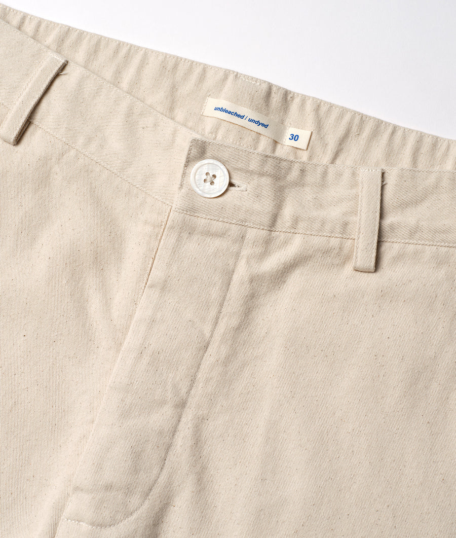 Detail shot of unbleached, undyed beige cotton trousers with a sewn-in size tag - Industry of All Nations