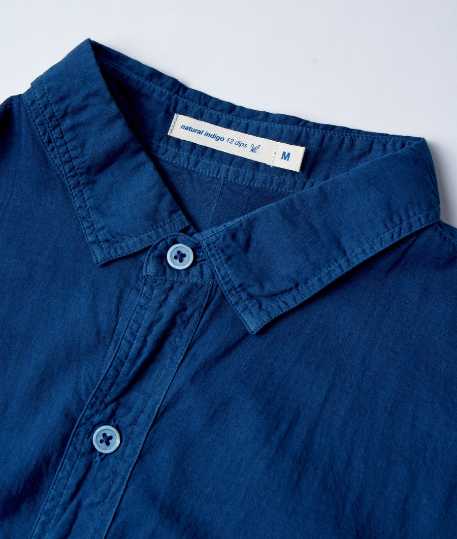 Flat lay detail shot of a navy blue collared shirt with a "natural indigo 12 clips" tag - Industry of All Nations