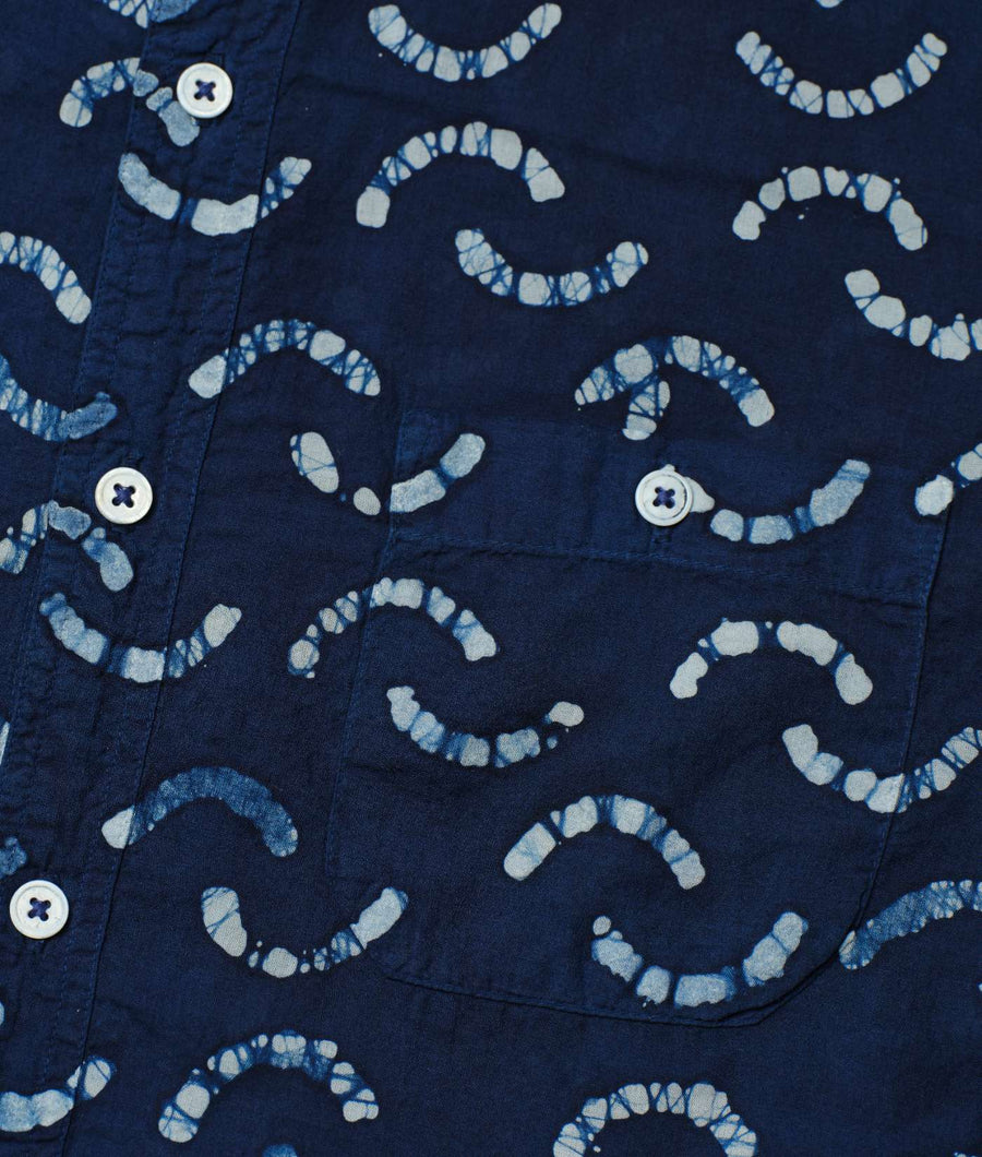 Detail shot of a blue organic cotton shirt with a repeating shibori-inspired circular pattern design - Industry of All Nations