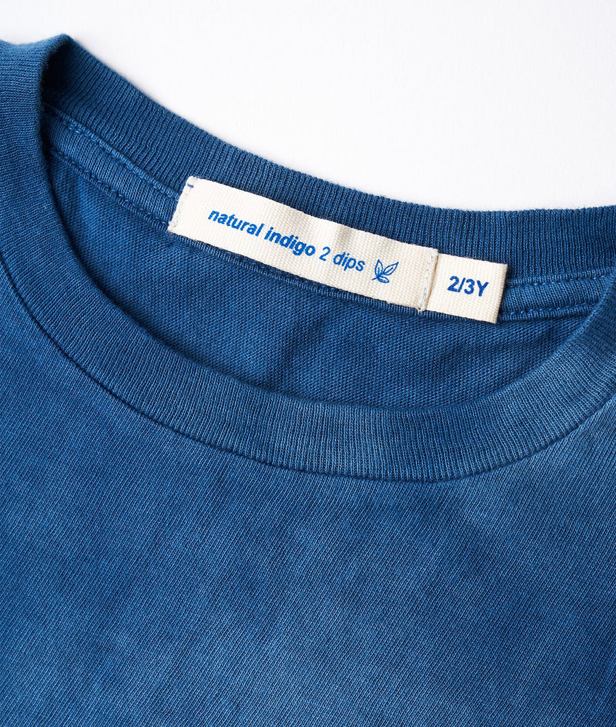 Close-up of a navy blue organic cotton T-shirt with 'natural indigo 2 dips' label on the collar - Industry of All Nations