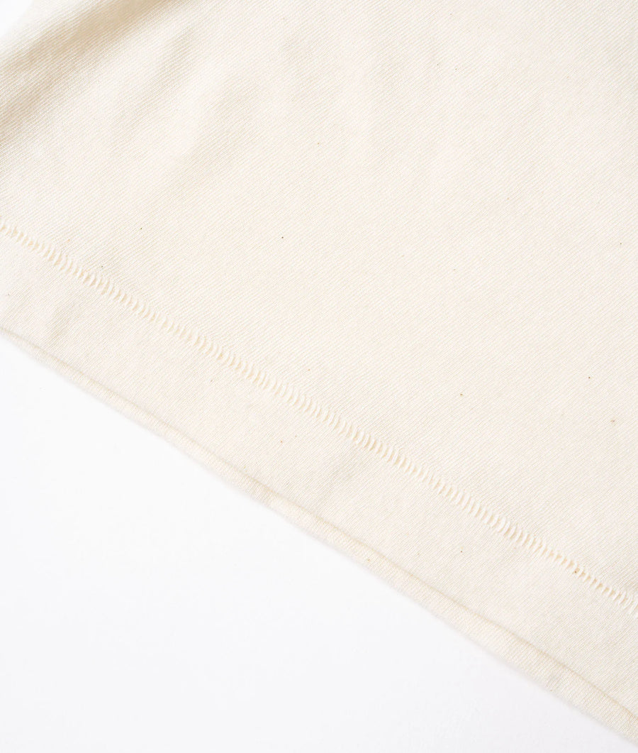 A flat lay image of an off-white woven cotton fabric with subtle stitching details - Industry of All Nations