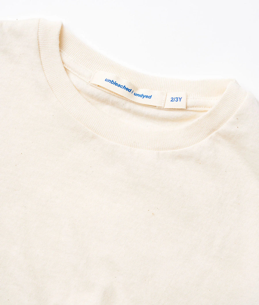 Detail shot of a cream-colored unbleached and undyed crew neck t-shirt with size label - Industry of All Nations