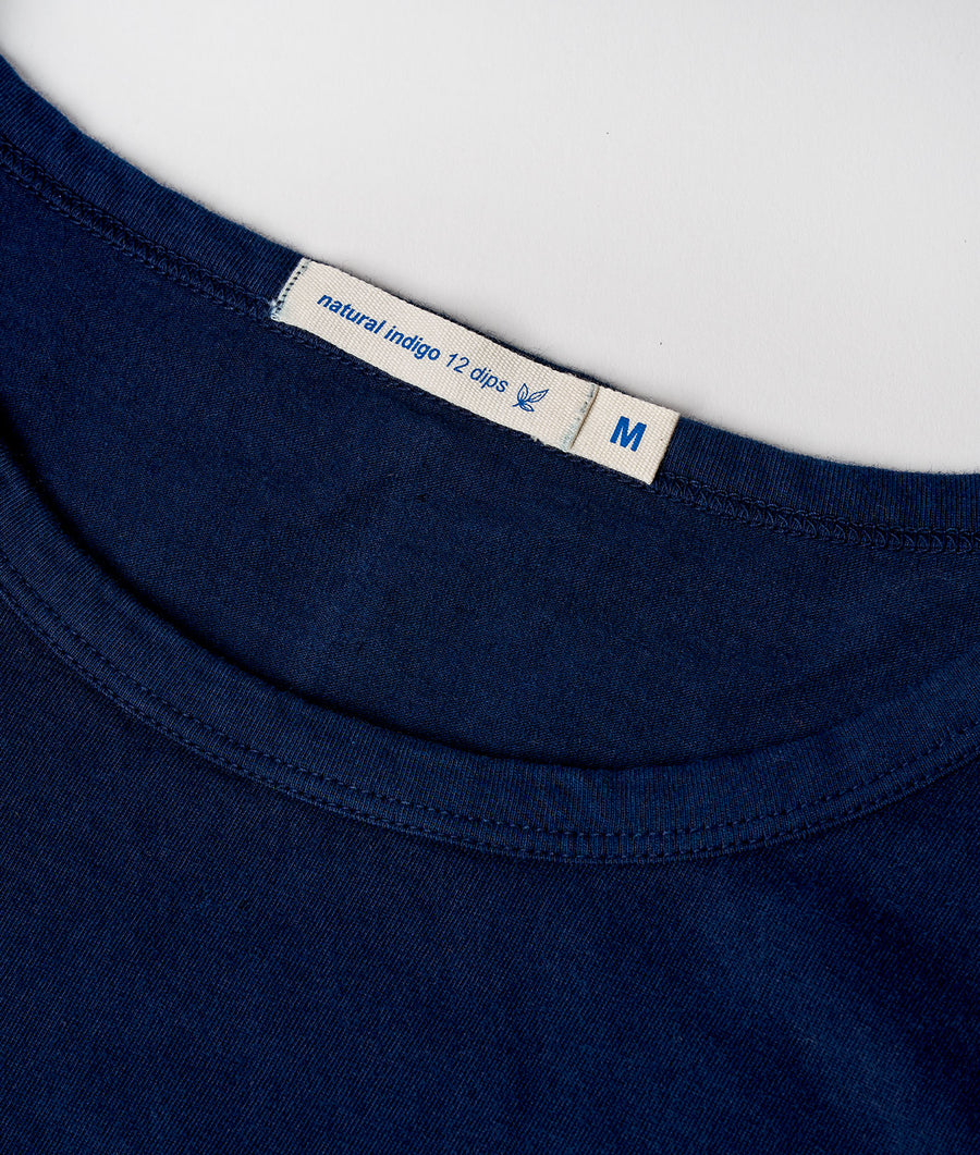 Close-up of a navy blue organic cotton t-shirt with a "natural indigo 12 dips" label - Industry of All Nations