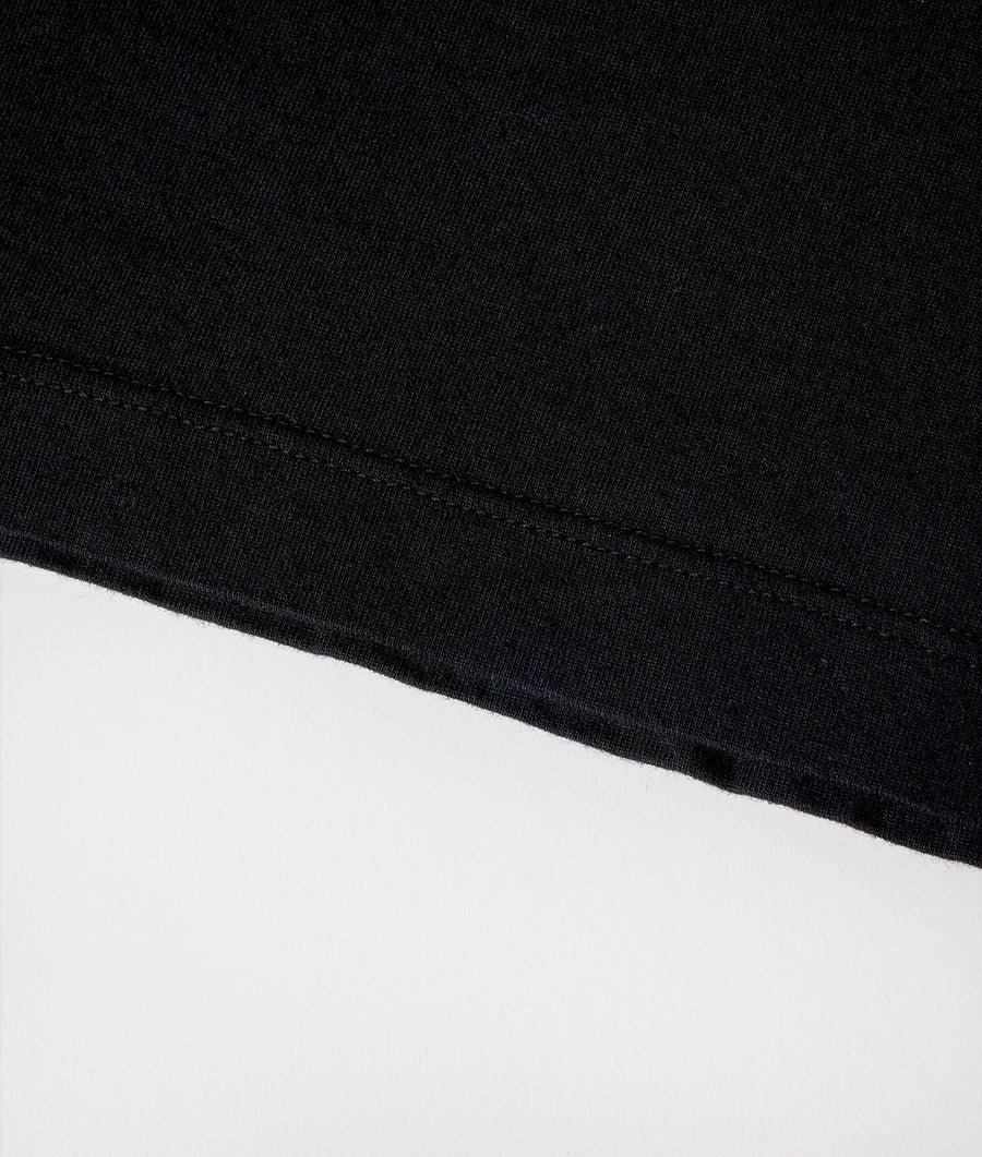 A close-up detail shot of a black cotton fabric, featuring a visible seam - Industry of All Nations