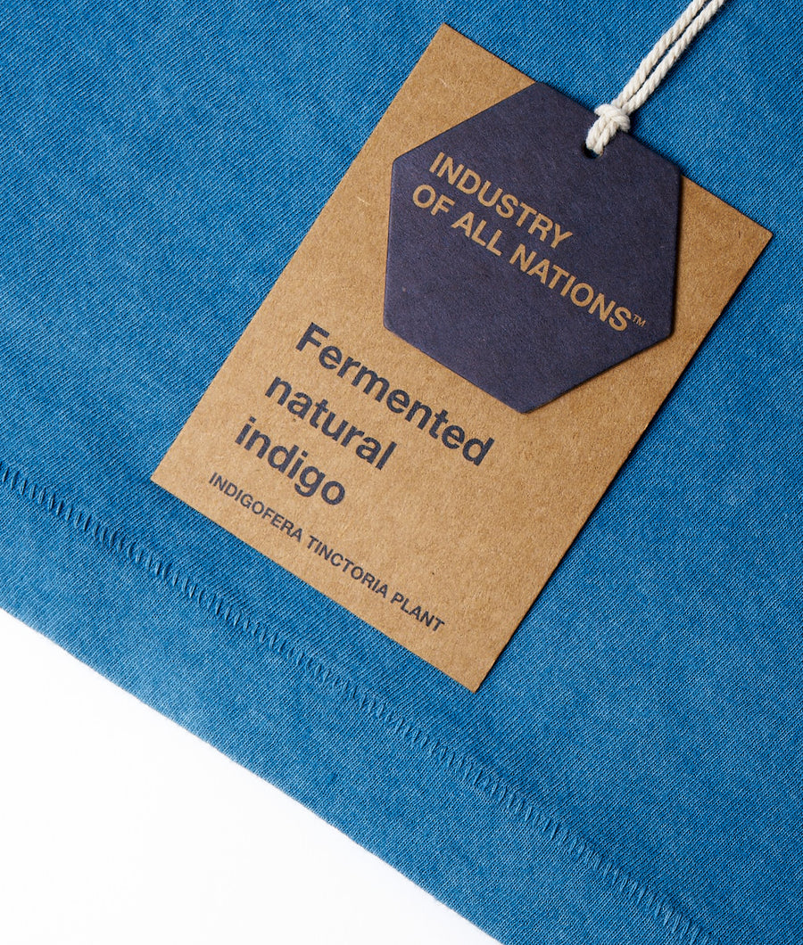 Fermented natural indigo dyed textile material on a blue background - Industry of All Nations