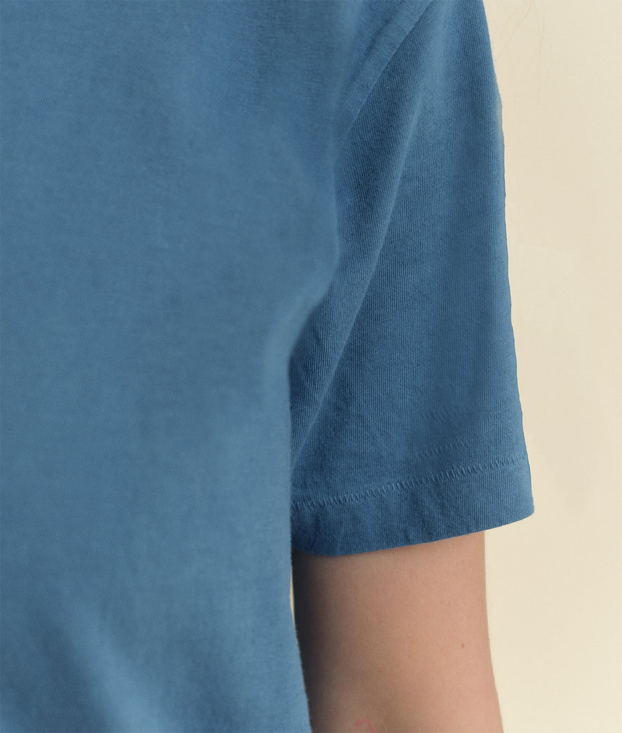 Detail shot of a blue organic cotton short sleeve t-shirt from Industry of All Nations.