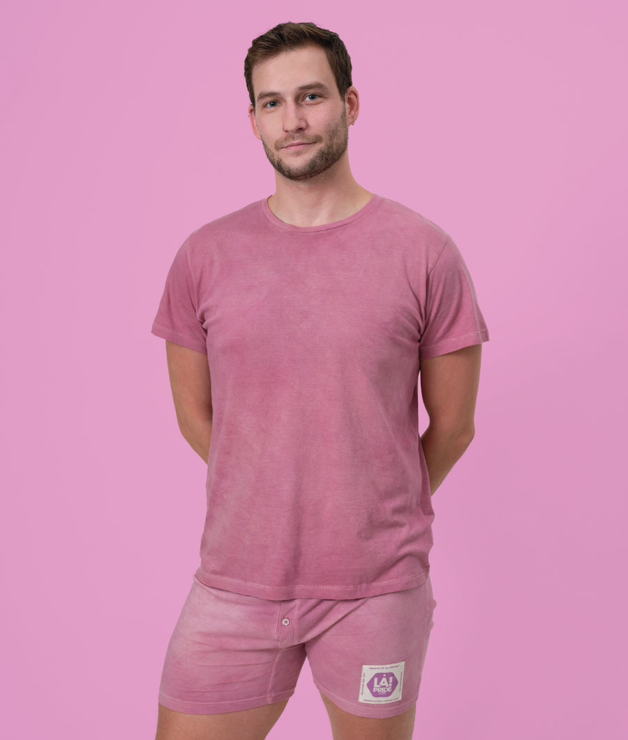 A pink organic cotton t-shirt worn by a male model on a pink background - Industry of All Nations