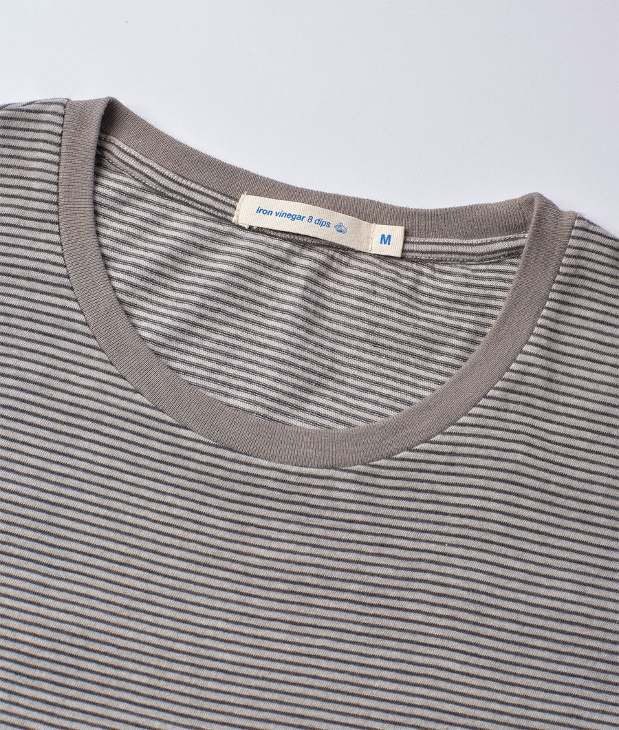 Close-up of a gray and white striped cotton t-shirt with an "Iron vinegar & dips" tag, displayed on a flat surface - Industry of All Nations