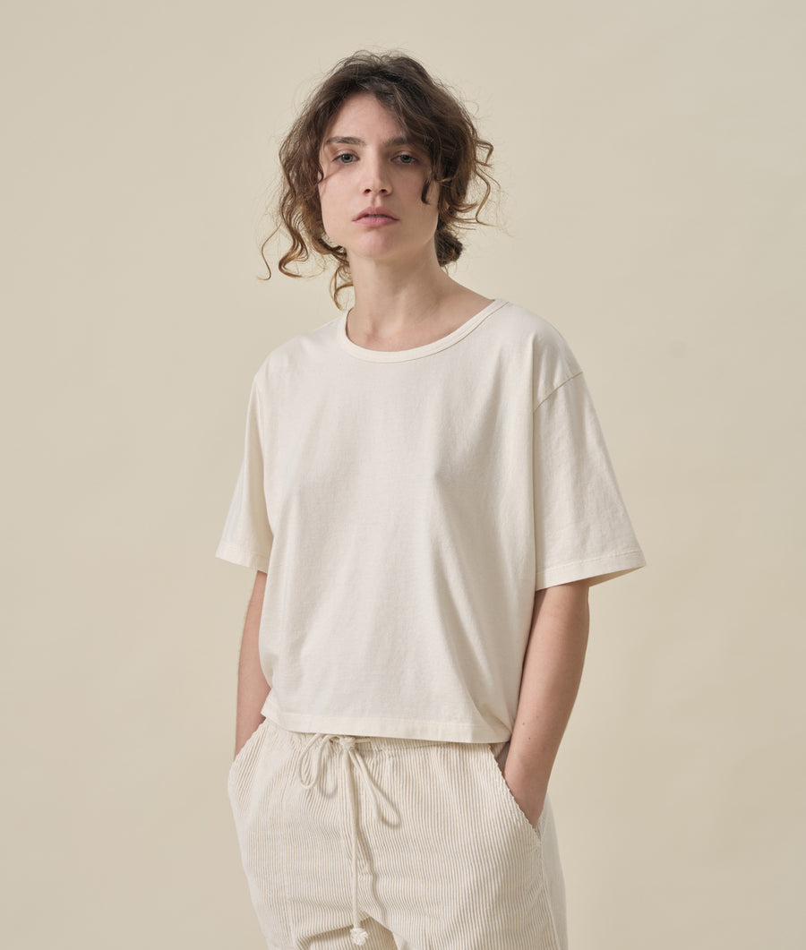 Portrait shot of a person wearing a relaxed-fit white cotton t-shirt with short sleeves - Industry of All Nations