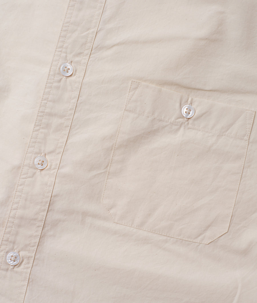 Beige cotton shirt with buttons, close-up view of the fabric and pockets - Industry of All Nations