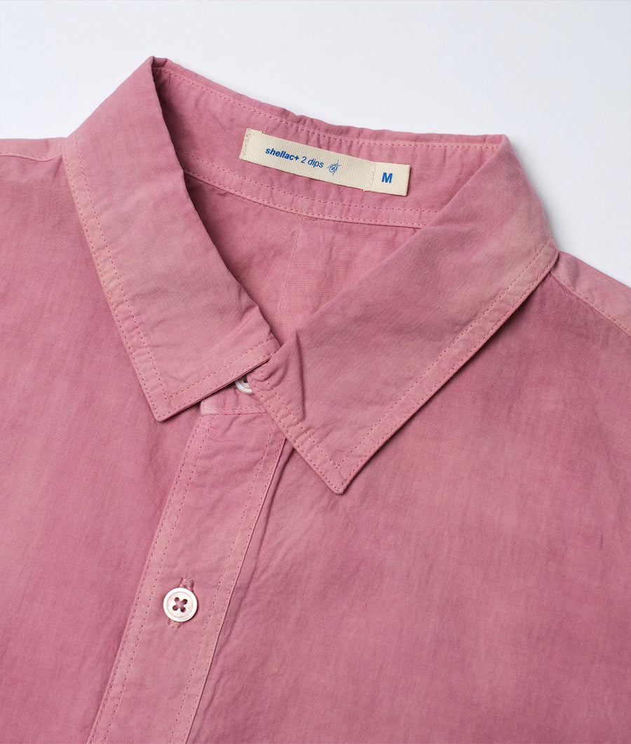 A detailed close-up shot of a soft pink button-up shirt from Industry of All Nations.