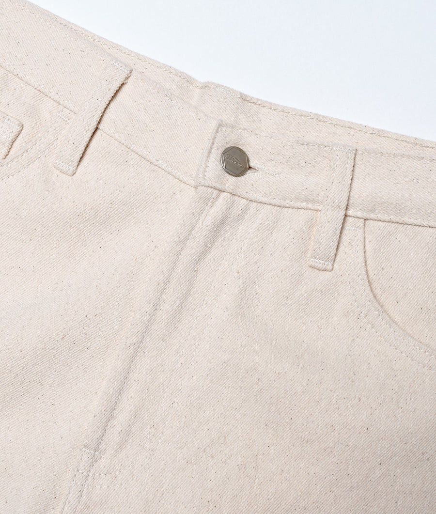 Detail shot of a beige organic cotton garment with a metal snap closure - Industry of All Nations