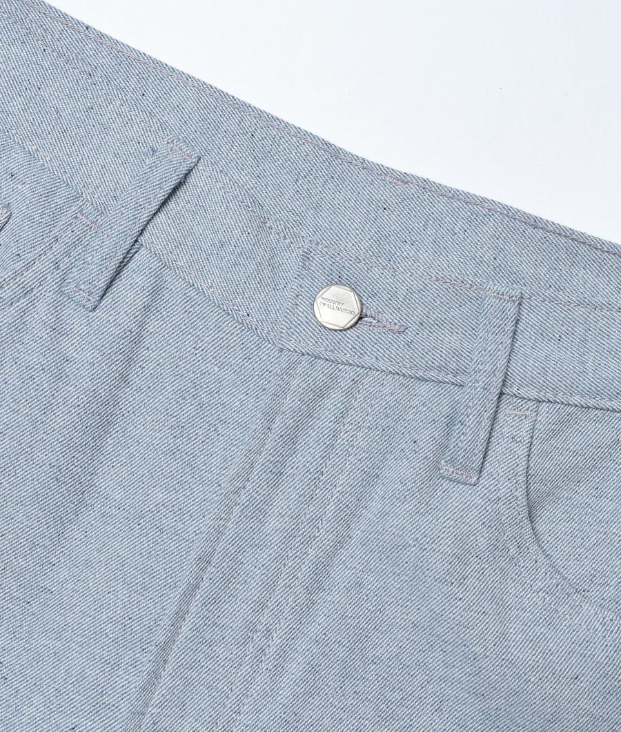 Detail shot of a grey cotton denim jacket with a metal button closure - Industry of All Nations