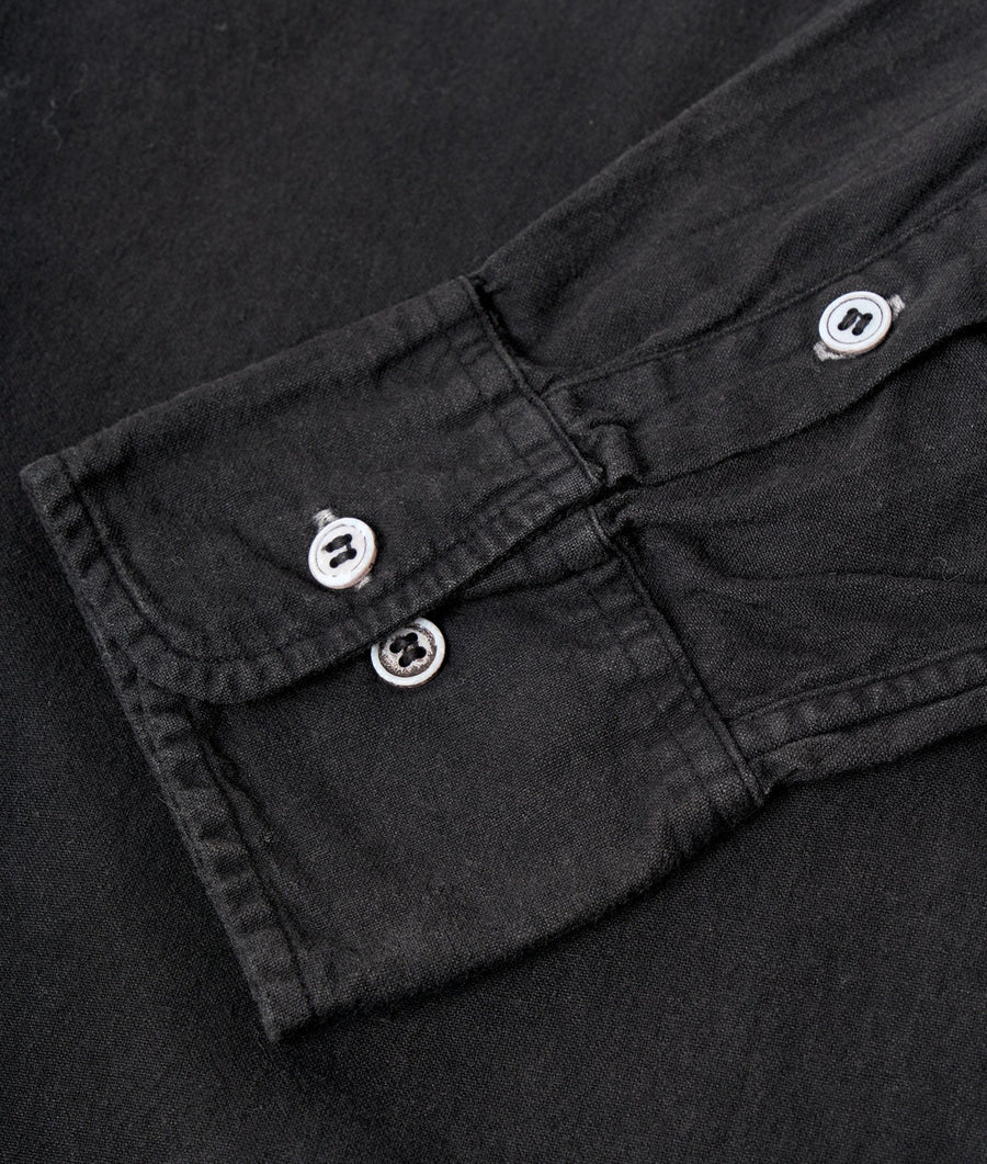 Black cotton jacket with buttons and pockets displayed in a close-up detail shot - Industry of All Nations
