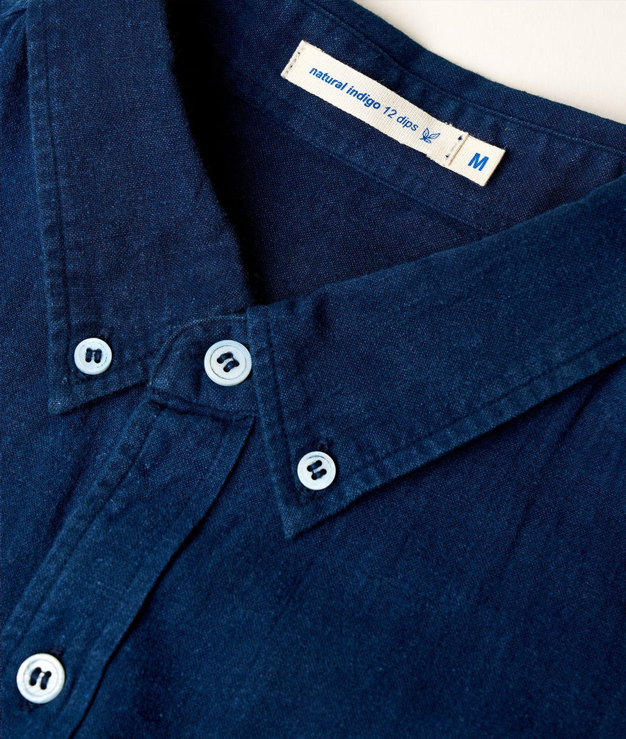 A close-up detail shot of a navy blue, natural indigo dyed cotton button-down shirt from Industry of All Nations.